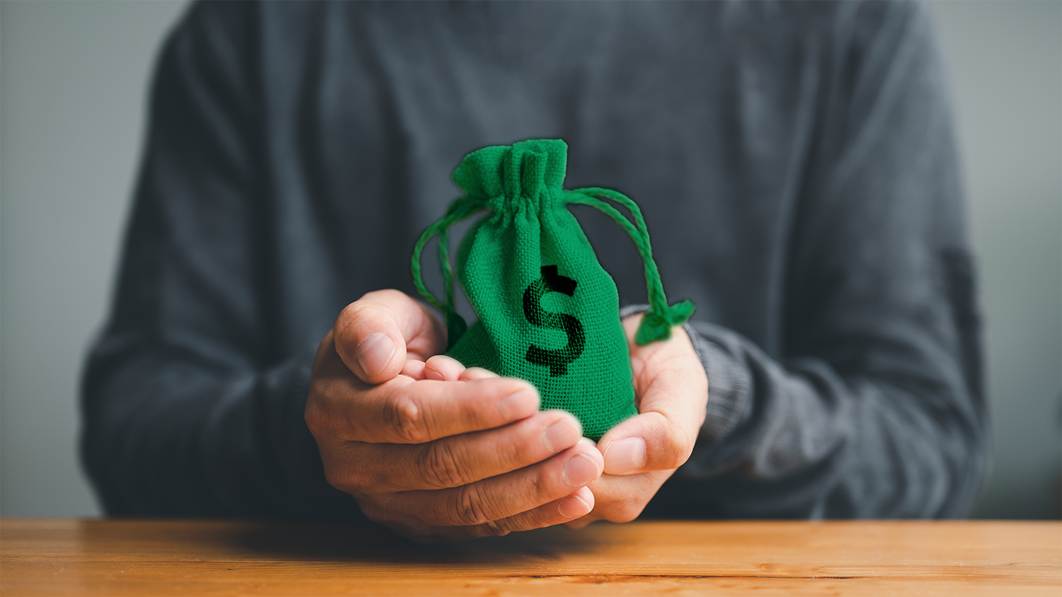 close up of a male holding a bag of money in his hands