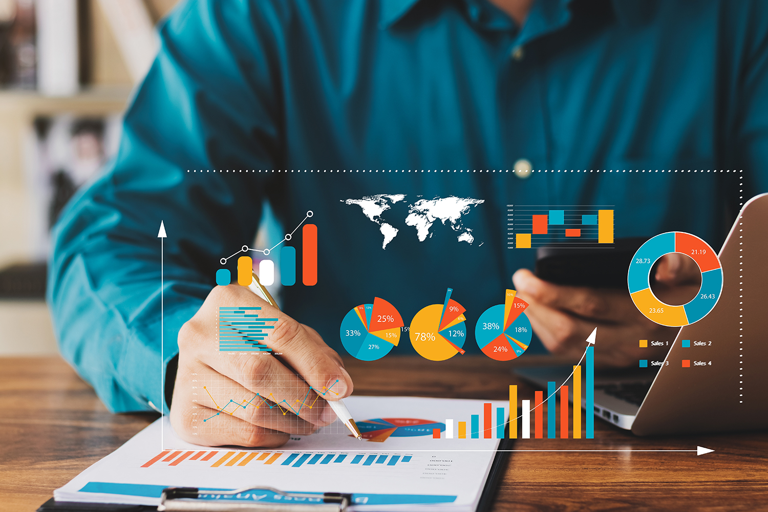 A person in a blue shirt is holding a phone and using a pen to point at a colorful chart on a document. Various graphs, charts, and a world map are digitally overlaid above the desk, suggesting data analysis or business work.