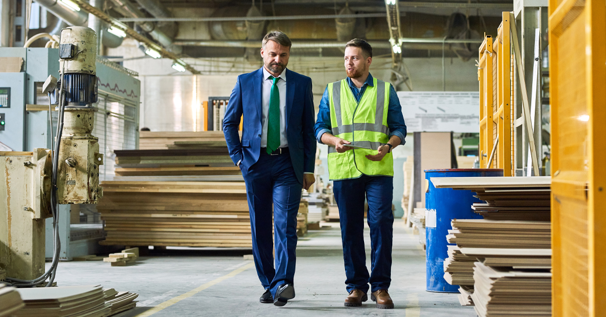 two men walking in a manufacturing shop and talking