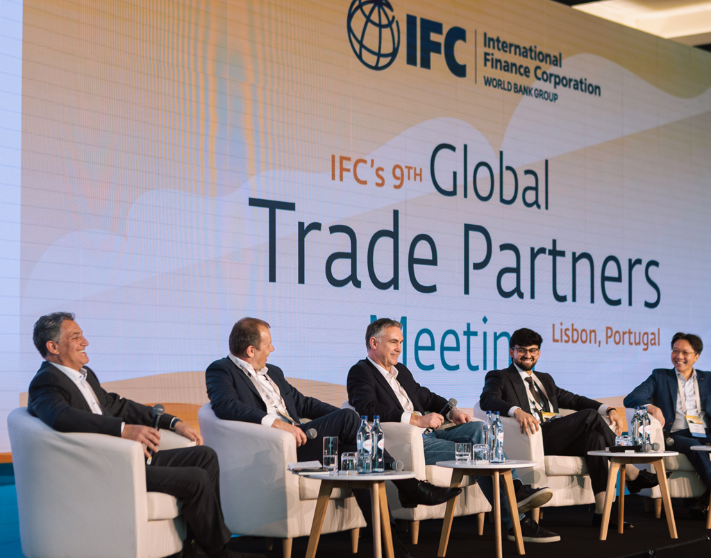 Five men in suits sit on stage at IFC’s 9th Global Trade Partners Meeting focused on Supply Chain Finance.